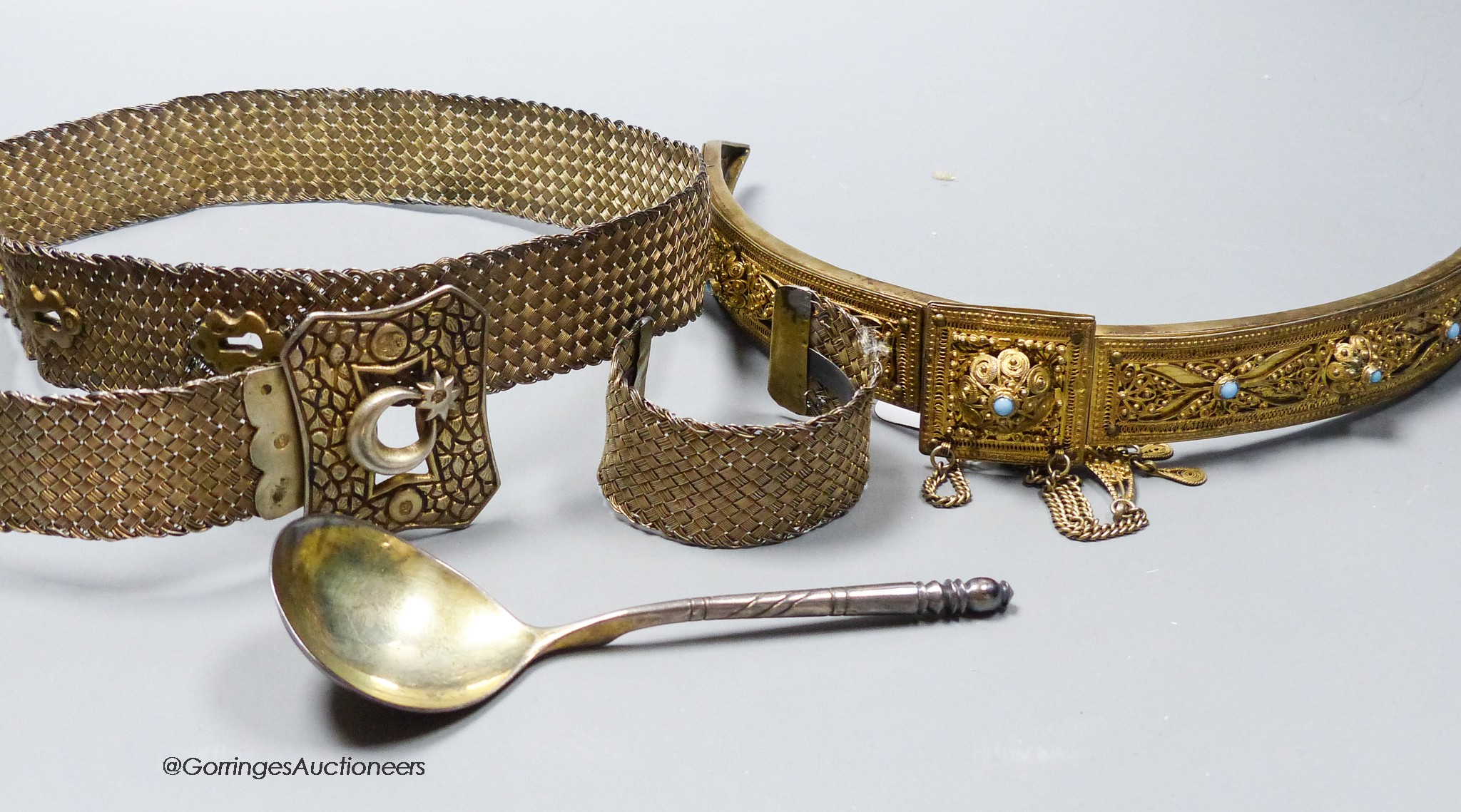 A late 19th century Russian 84 zolotnik and niello spoon, 14.8cm, a Russian gilt 84 zolotnik and turquoise set evening bag mount?, together with a Turkish metal belt and bangle.
